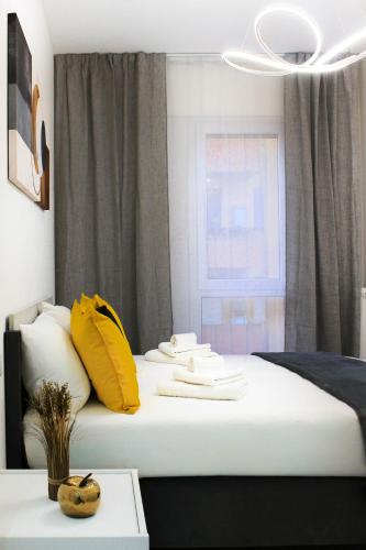 un lit avec des oreillers jaunes et blancs et une fenêtre dans l'établissement Golden Nest Padova, à Padoue