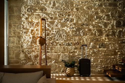 a room with a brick wall with a suitcase at Casa Siva in Sívas