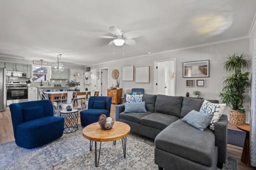 een woonkamer met een bank en blauwe stoelen bij 4bdrm OKI Gem - Steps to Beach with Poolside Oasis in Yaupon Beach