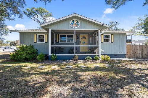 een groen huis met een hek ervoor bij 4bdrm OKI Gem - Steps to Beach with Poolside Oasis in Yaupon Beach