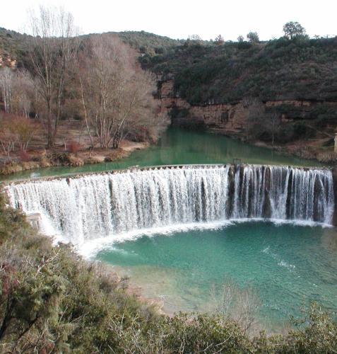 a waterfall with a pool of water in a river at Hotel Era Conte in Bierge