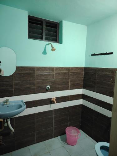 a bathroom with a sink and a toilet at JANATHA home stay in Varkala
