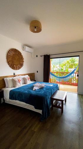 a bedroom with a bed and a large window at Pousada Amaris in Penha