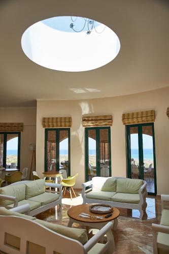 a living room with couches and tables and a large ceiling at Element Hotel in Elafonisos