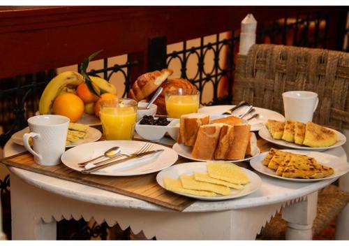 a table with plates of breakfast food on it at Riad Dar Iman in Fès