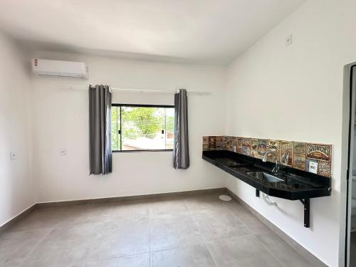 a white room with a sink and a window at Pousada caminho das águas in Pirenópolis