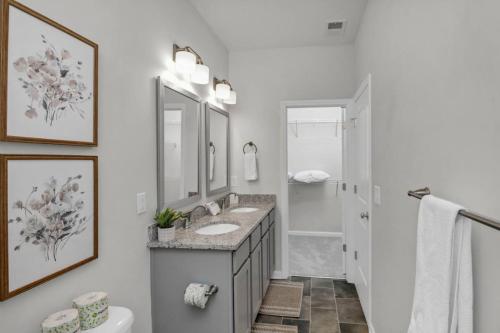 a white bathroom with two sinks and a toilet at The Augusta Cottage WECO 3Br in West Columbia