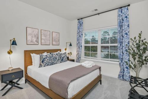 a bedroom with a bed and a large window at The Augusta Cottage WECO 3Br in West Columbia