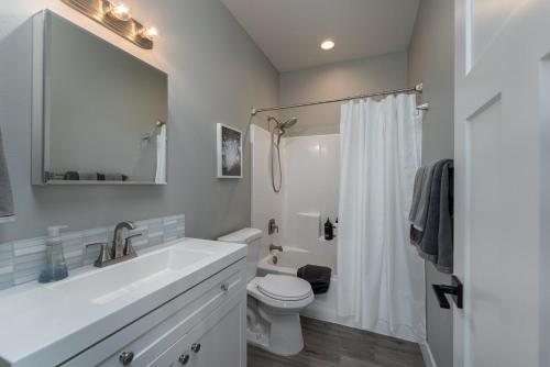 a white bathroom with a sink and a toilet at River & Garden View Suite of Kalama Oaks Lodge in Kelso