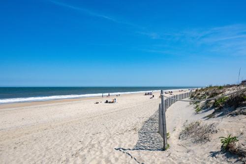 a beach with people on the sand and the ocean at 70 Steps to Beach Dewey Beach in Dewey Beach
