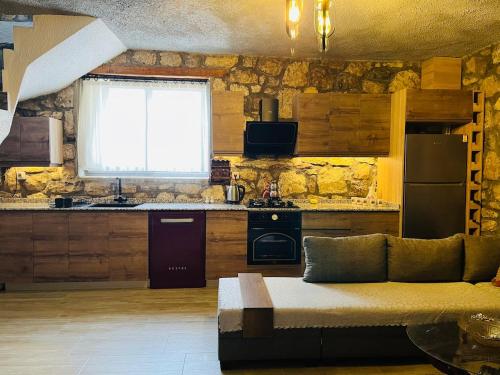 een woonkamer met een bank en een keuken bij Kösedere Stone Houses in Karaburun