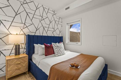 een slaapkamer met een kingsize bed met een blauw hoofdeinde bij Rockies Getaway Condo With Mountain View in Canmore
