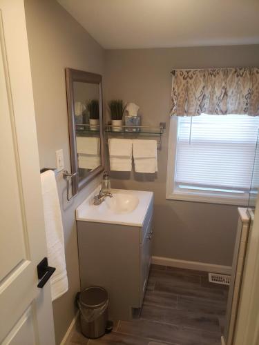 a bathroom with a sink and a mirror and a window at Attractive and Cozy Apartment - 4 bdrms 2 bths in Paterson