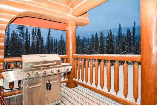 a grill on a deck with a view of trees at Charming Rustic Cabin Perfect for Groups in Golden