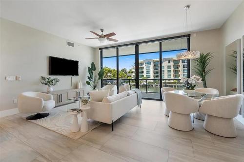ein Wohnzimmer mit weißen Möbeln und einem Flachbild-TV in der Unterkunft Chic Three-Bedroom Waterfront Condo With Private Balcony in Fort Lauderdale