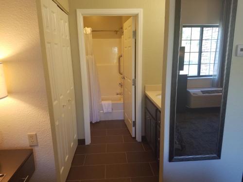 a bathroom with a tub and a sink and a mirror at Staybridge Suites - Cincinnati North, an IHG Hotel in West Chester