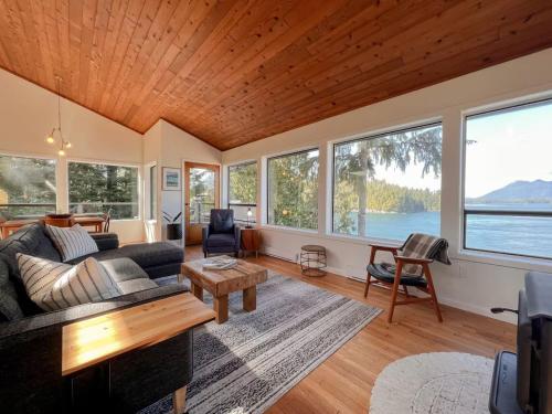 ein Wohnzimmer mit Sofa und Tisch in der Unterkunft Marielles Lookout - Your Oceanfront Escape Framed by Forest & Waves in Tofino