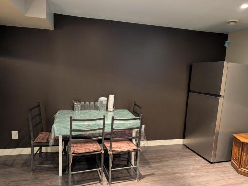 埃德蒙顿2-Room Suite in South Edmonton的餐桌、椅子和冰箱