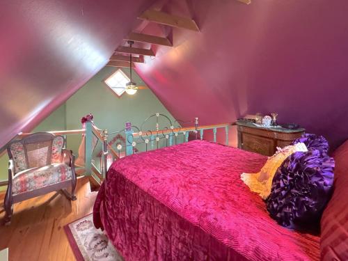 a bedroom with a pink bed and a chair at Blue Crystal Hideaway BnB in Eureka Springs