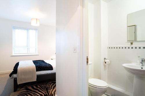 a white bathroom with a bed and a sink at Apt - Stay 6 - Stadium View - Coo-op Live Arena in Manchester