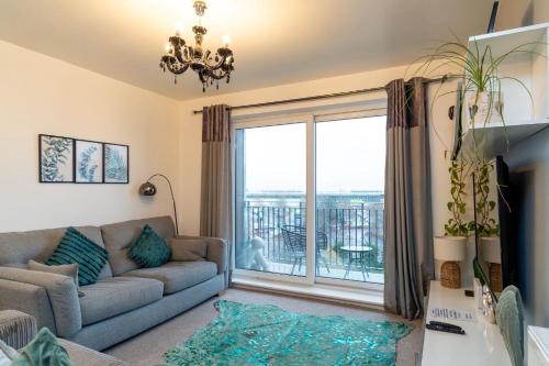 a living room with a couch and a large window at Apt - Stay 6 - Stadium View - Coo-op Live Arena in Manchester