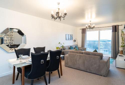 a living room with a couch and a table and chairs at Apt - Stay 6 - Stadium View - Coo-op Live Arena in Manchester