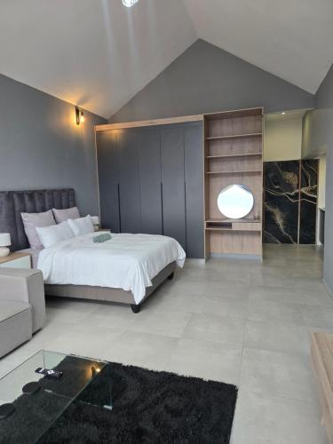 ein Schlafzimmer mit einem großen Bett und einer Couch in der Unterkunft iThusi stream in Mbabane