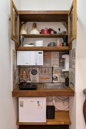 Studio Privativo 3 min Centro para 4 pessoas com 2 quartos ar condicionado في أبرلانديا: مطبخ مع حوض وميكروويف