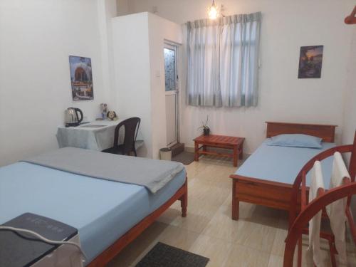 CANAAN MUSIC Hotel في موراتوا: غرفة بسريرين ومغسلة وطاولة