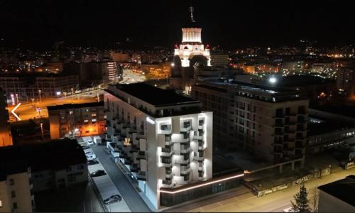 vista su una città di notte con torre dell'orologio di Harmony Suite a Baia Mare