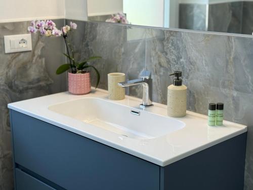 een badkamer met een witte wastafel en een spiegel bij Il Casalone in Ponte a Tressa