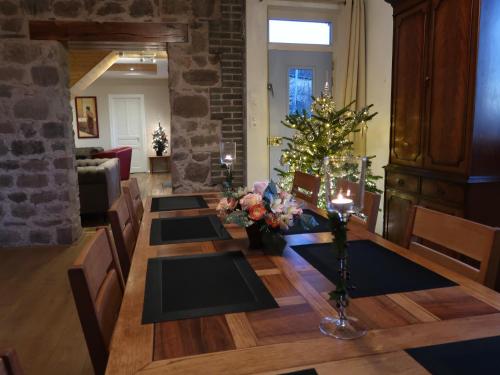 a dining room with a table and a christmas tree at Maison La Chapelle Bellevue in Saint-Solve