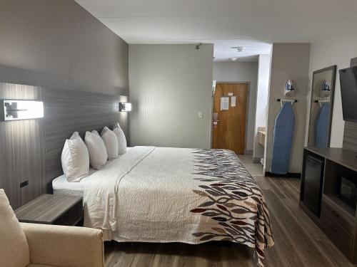 a hotel room with a large bed and a couch at Red Roof Inn & Suites Middleborough in Middleboro