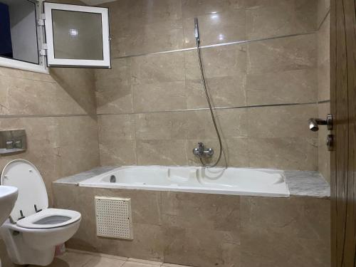 a bathroom with a bath tub and a toilet at Luxe & Sérénité Sahloul 4 in Sousse