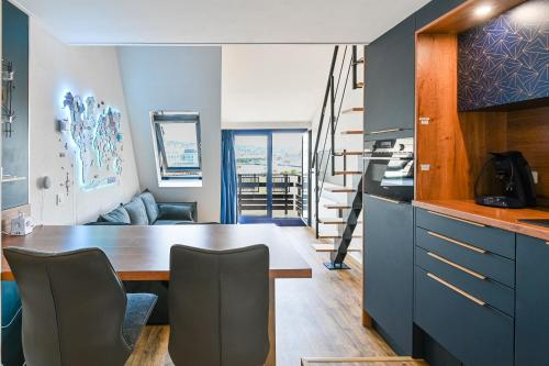 Mini-duplex cosy avec magnifique vue mer في دوفيل: مطبخ وغرفة معيشة مع طاولة وكراسي