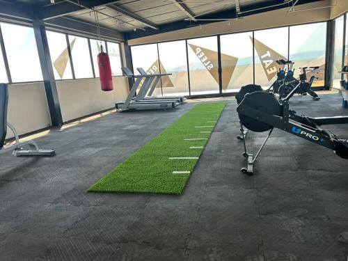 Un gimnasio con un helicóptero y una alfombra verde. en Apartment near Zona Real Zapopan, en Guadalajara