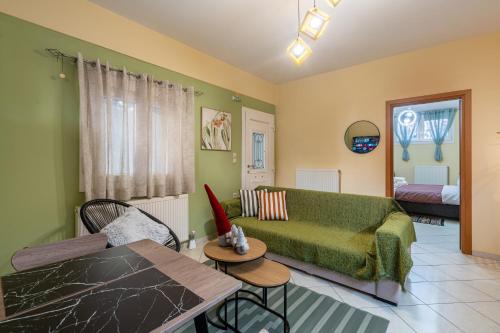 a living room with a green couch and a table at 50 Cube - Mountain Nook Karpenisi in Karpenisi