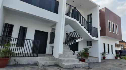 a white house with stairs and a building at White Orchid Inn in Ibadan