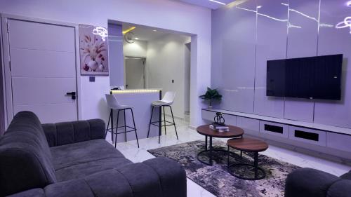 a living room with a couch and a flat screen tv at White Orchid Inn in Ibadan