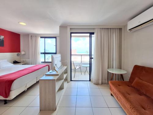 a hotel room with a bed and a couch at Flats Vista Mar PontaNegra in Natal