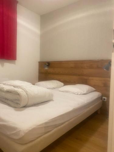 Les toits de dévoluy في لو ديفولي: سريرين بشرشف ووسائد بيضاء في الغرفة