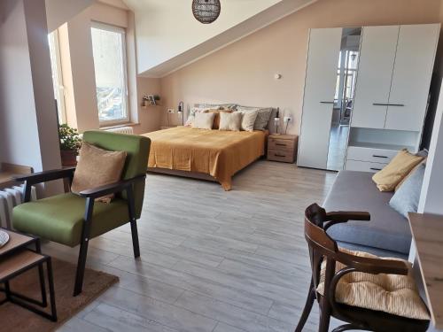 a bedroom with a bed and a chair and a table at Pogled Ada 1 in Belgrade