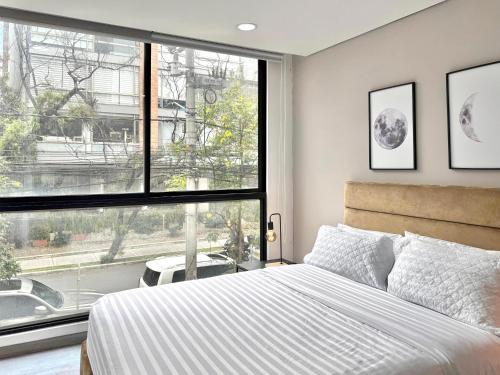 a bedroom with a bed and a large window at EspacioYa By Mario Rental Calle 100 in Bogotá