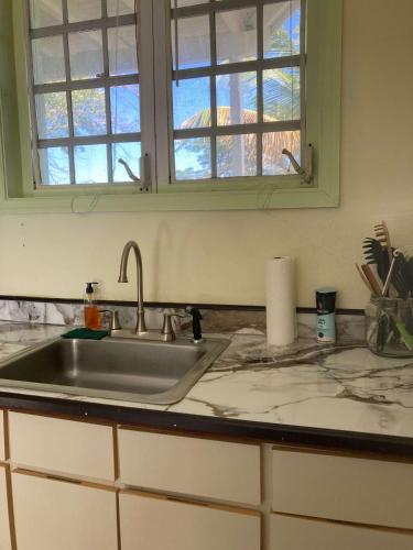 a kitchen counter with a sink and a window at King Deluxe Plus Cottage at Boundless Bliss Hotel in Raphune