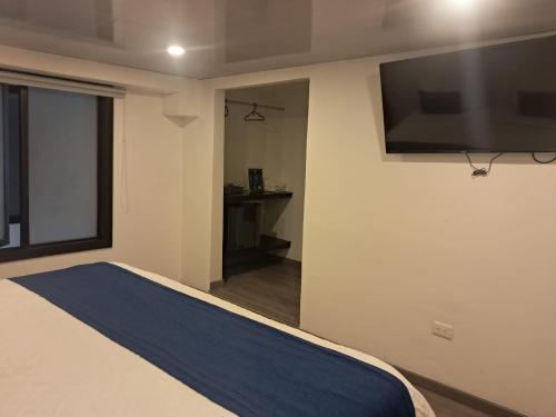 ボゴタにあるHotel Embajada 44のベッドと薄型テレビのある寝室