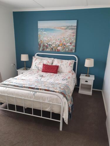 a bedroom with a bed with a painting on the wall at Cozy Home Style Accommodation in Marong