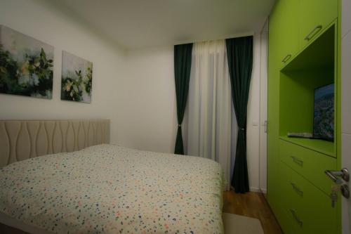 een slaapkamer met een bed en een groene deur bij Pro-Link Podgorica in Podgorica