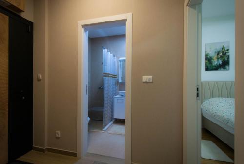 een kamer met een badkamer met een toilet en een bed bij Pro-Link Podgorica in Podgorica