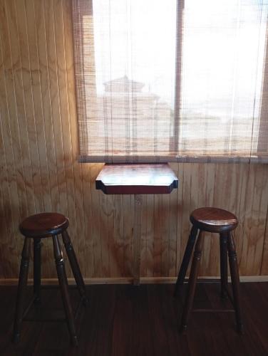 Cabaña Jacinta في La Boca: طاولة و كرسيين امام النافذة