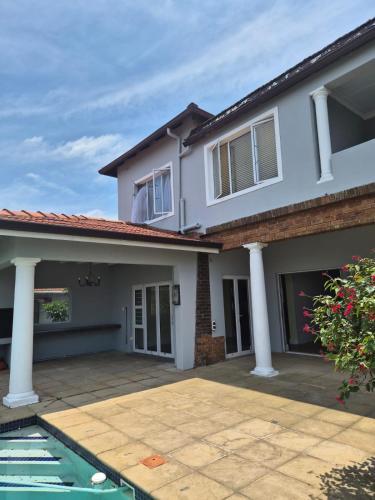 a large white house with a patio in front of it at Holland Manor in Durban